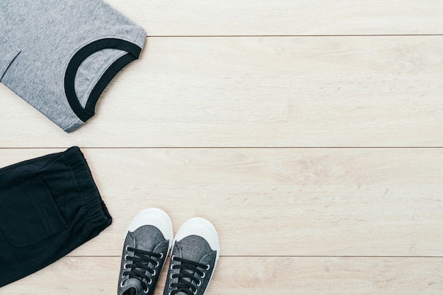 Foto grátis t-shirt com calças e sapatos sobre fundo de madeira