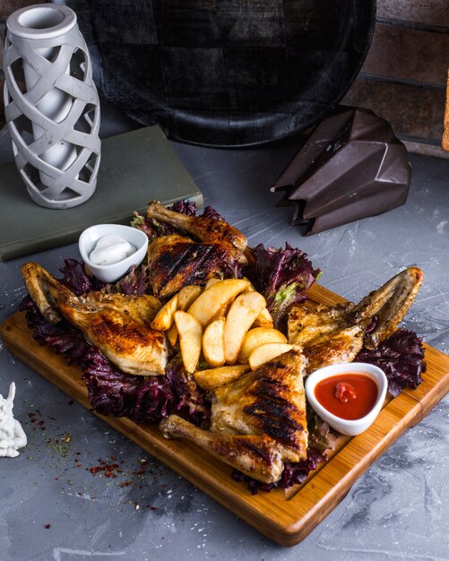 Tabaca de frango frito com batatas na placa de madeira