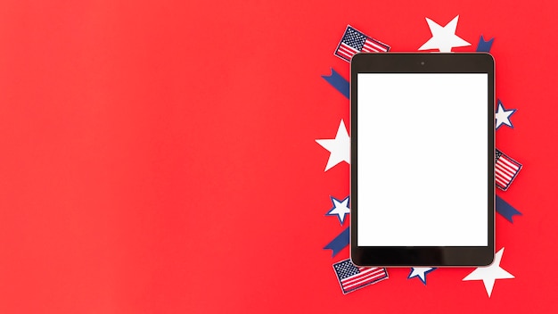 Tablet com elementos decorativos da bandeira americana na superfície vermelha