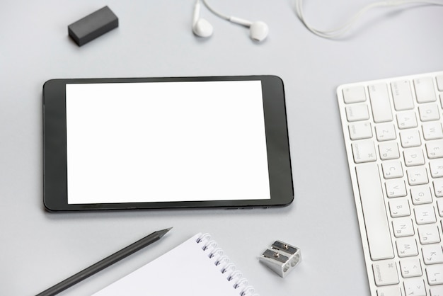 Tablet digital em branco branco na mesa de escritório cinza