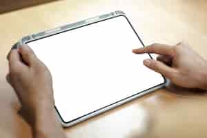 Foto grátis tablet digital em branco em uma mesa de madeira clara