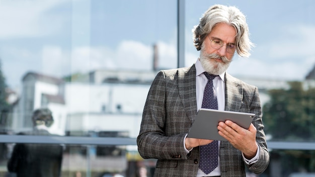 Foto grátis tablet masculino maduro elegante com vista frontal