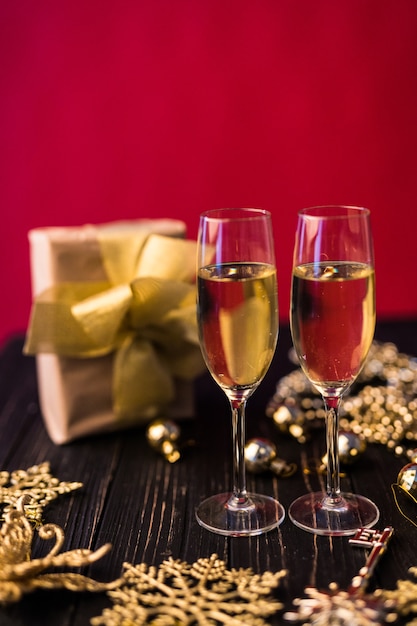Taça de champanhe com caixas de presente e decorações de Natal. Presente para um especial.