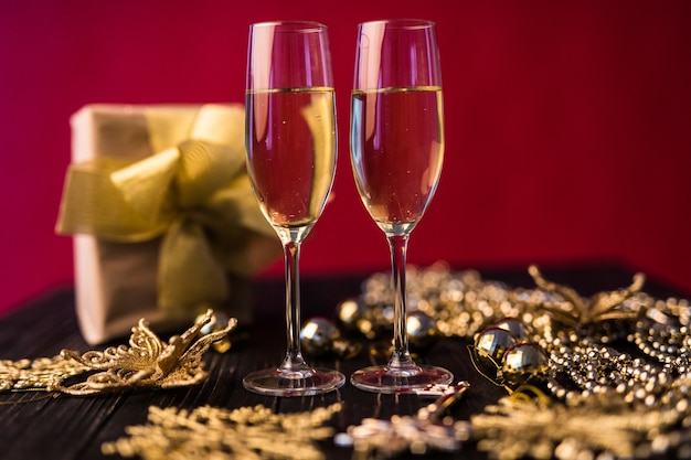 Taça de champanhe com caixas de presente e decorações de Natal. Presente para um especial.