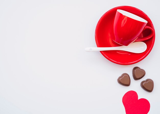 Taça na placa perto de bombons doces de chocolate e cartão de dia dos namorados