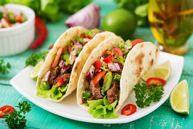 Tacos mexicanos com carne em molho de tomate e salsa