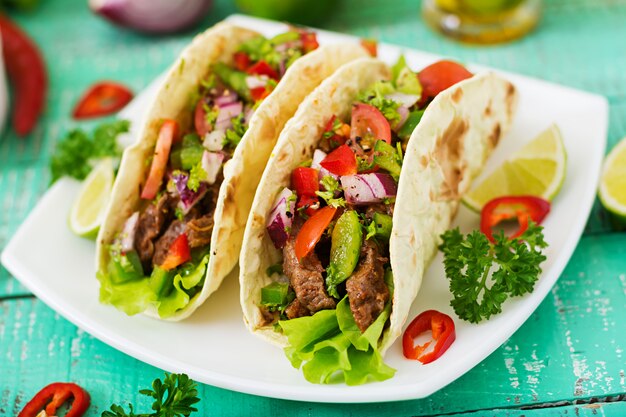 Tacos mexicanos com carne em molho de tomate e salsa