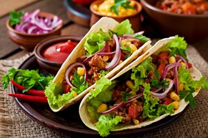 Tacos mexicanos com carne, legumes e cebola vermelha