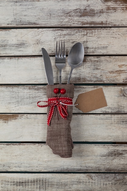 Talheres embrulhados com motivo do Natal em uma mesa de madeira