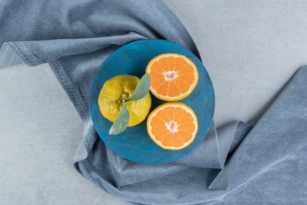 Tangerinas em um quadro azul em um pedaço de tecido, em mármore