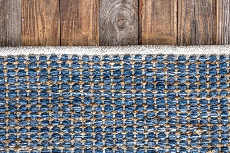 Foto grátis tapete de área de denim geométrico tecido à mão no chão de madeira