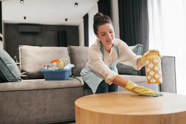 Tarefas. Uma mulher limpando uma superfície de mesa com desinfetante