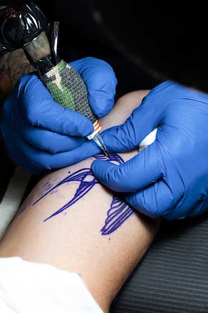 Tatuador experiente trabalhando na tatuagem do cliente