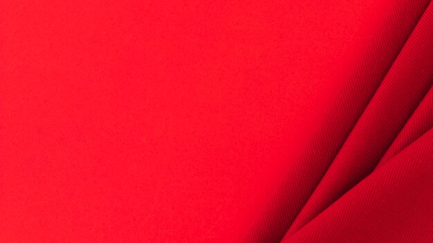 Tecido têxtil vermelho dobrado em fundo colorido