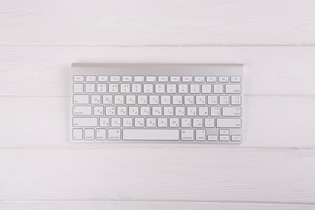 Teclado branco na mesa de madeira