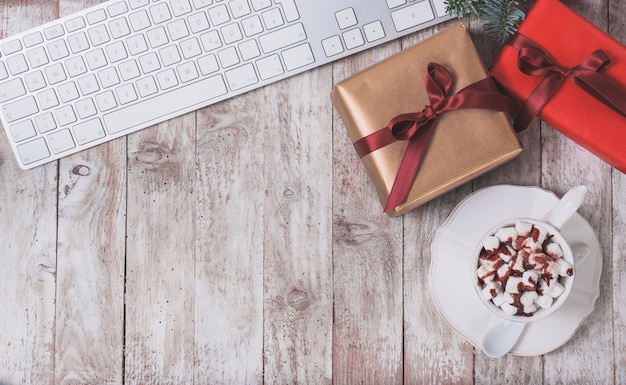 Teclado de computador, presente do natal e copo com marshmallows