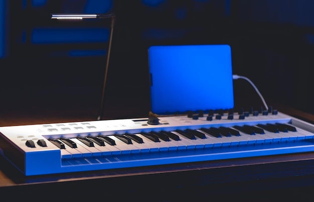 Teclado musical e tablet em uma produção musical de sala escura