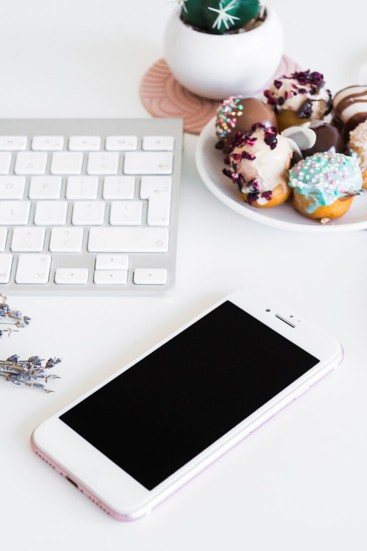 Foto grátis teclado perto de smartphone e cookies na placa