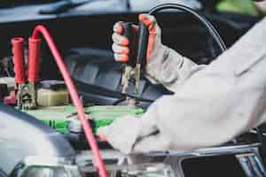 Foto grátis técnico de automóveis, vestindo um uniforme branco, de pé e segurando uma chave inglesa, que é uma ferramenta essencial para um mecânico