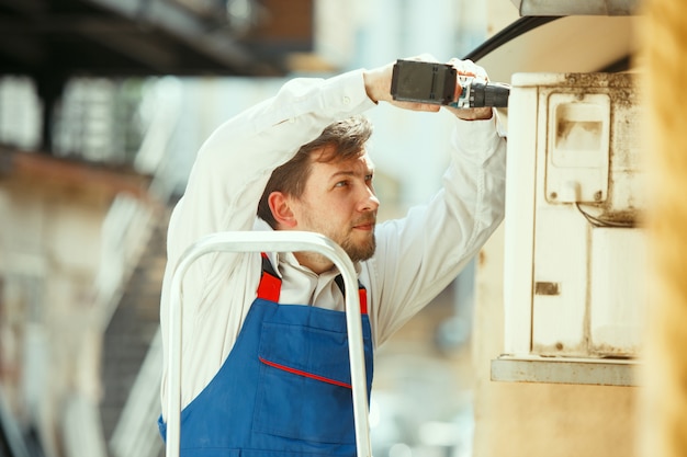 Técnico de HVAC trabalhando em uma peça de capacitor para unidade de condensação