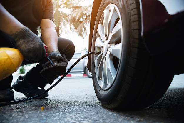 Técnico é inflar pneu de carro - conceito de segurança de transporte de serviço de manutenção de carro