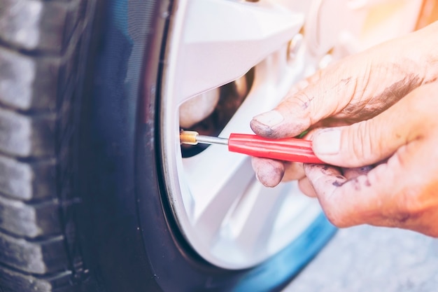 Técnico está consertando o pneu do carro