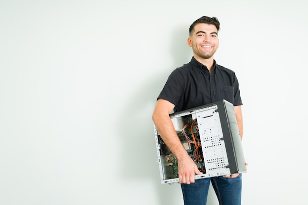 Foto grátis técnico feliz se sentindo animado ao carregar um computador cpu reparado para entregá-lo a um cliente em sua oficina