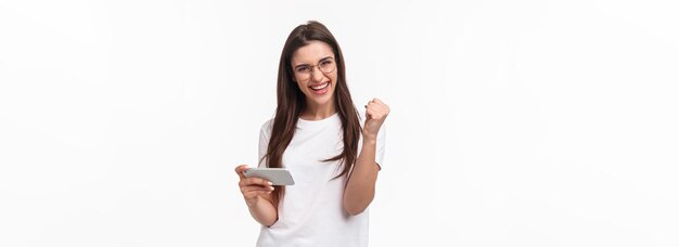 Foto grátis tecnologia de comunicação e retrato do conceito de estilo de vida de uma garota de sorte alegre e bem-sucedida ganhando pr