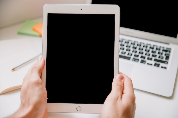 Tecnologia e conceito de mesa com as mãos segurando o tablet