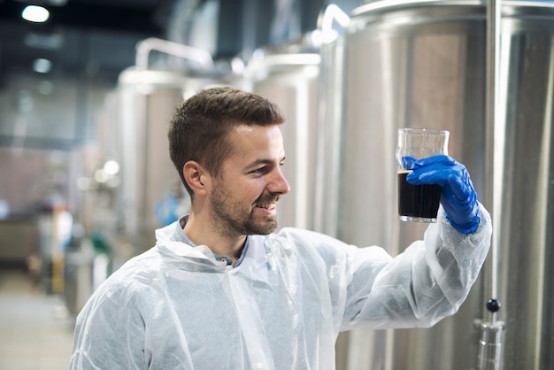 Tecnólogo verificando a qualidade do produto em planta de produção de álcool para bebidas