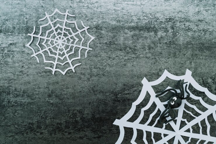 Foto grátis teia de papel com aranha de brinquedo em fundo cinza