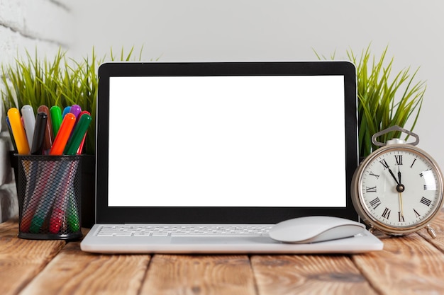 Tela em branco do laptop do espaço de trabalho na mesa de madeira