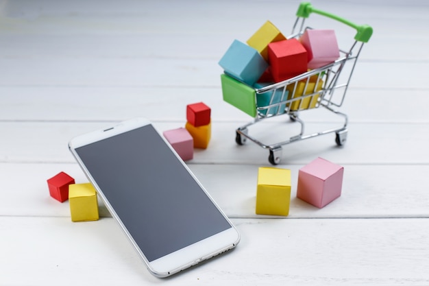 Telefone celular e carrinho de compras, compras on-line, conceito de compras móveis