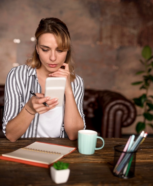 Foto grátis telefone de verificação da mulher freelance