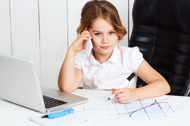 Telefone falando da menina bonita nova no local de trabalho no escritório.