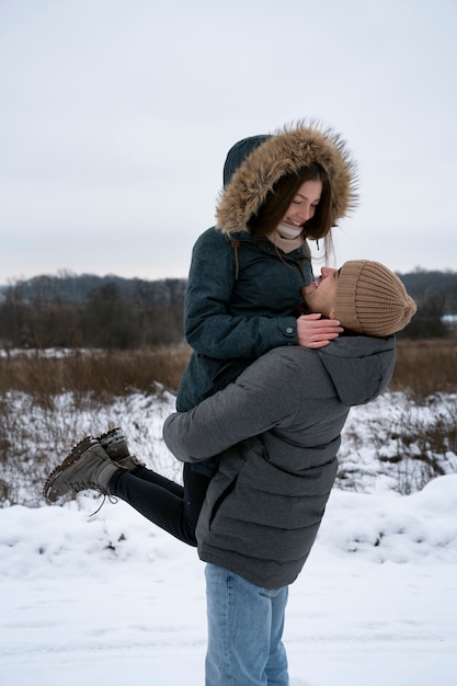 Foto grátis temporada de inverno de casal feliz de tiro médio