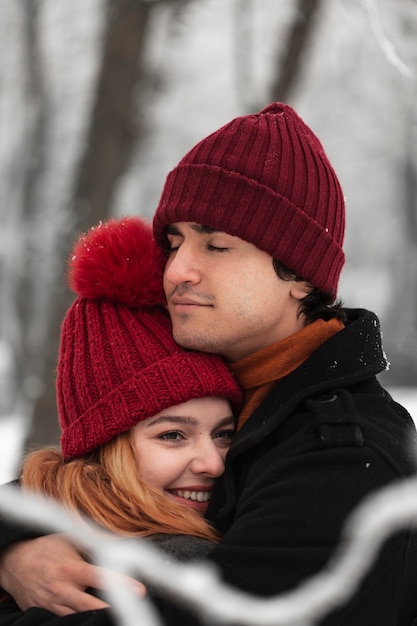 Temporada de inverno nevado com casal abraçando
