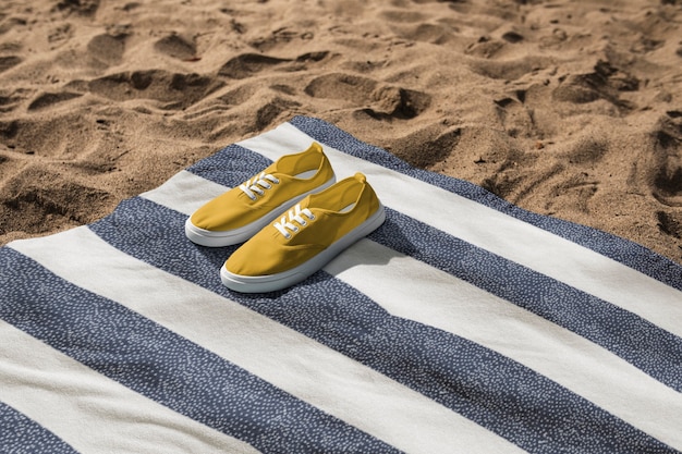 Foto grátis tênis amarelo em toalha de praia fotografia vibrações de verão