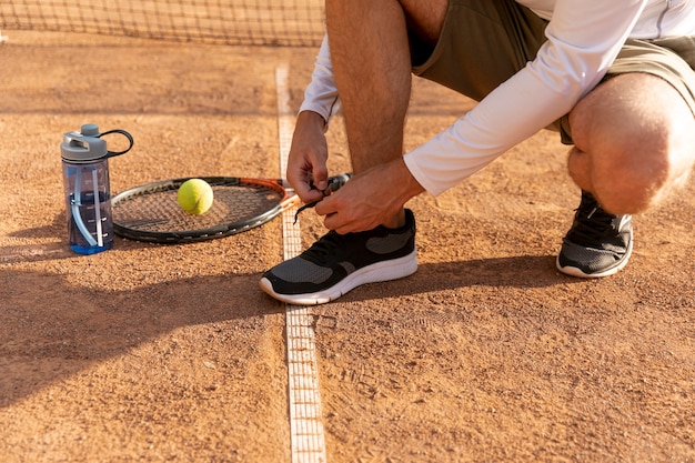 Foto grátis tenista, amarrando, seu, sapatos