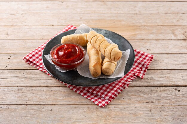 Tequenos latino-americanos recheados de queijo na mesa de madeira