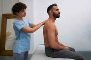 Foto grátis terapeuta feminina no centro de reabilitação dando massagem nas costas