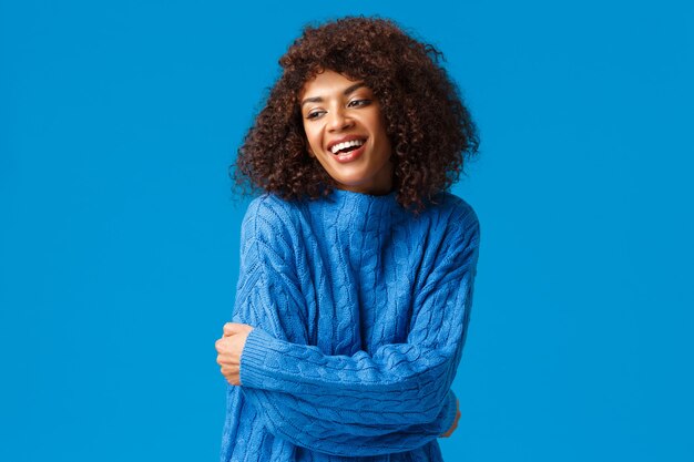 Terno, romântico e sensual, sorrindo muito afro-americana, abraçando o próprio corpo, conceito de autoacaptência. olhando alegremente para o lado, abraçando-se para se aquecer