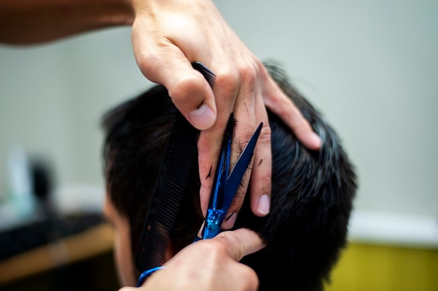 Tesoura e mãos no cabelo do cliente