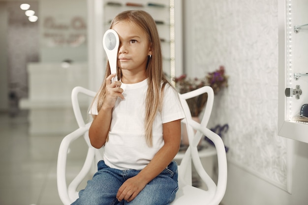 Foto grátis teste oftalmológico infantil e exame oftalmológico. menina fazendo exame de olho, com foróptero. teste de olho para crianças