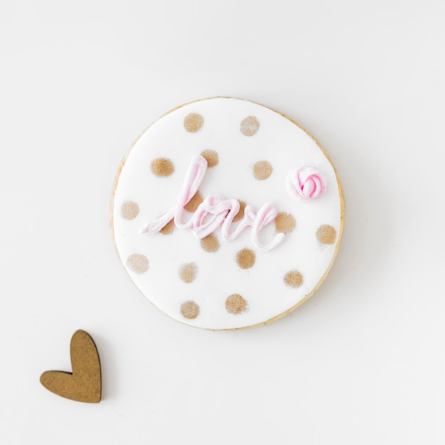 Texto de amor-de-rosa no cookie caseiro com forma de coração sobre fundo branco