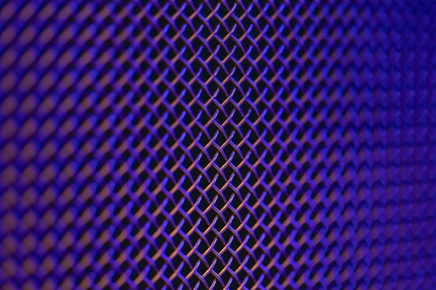 Textura de close-up de grelha de metal de um alto-falante de música em iluminação colorida