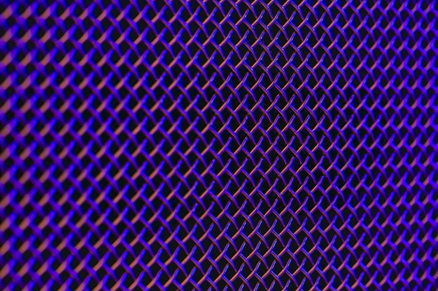 Textura de close-up de grelha de metal de um alto-falante de música em iluminação colorida