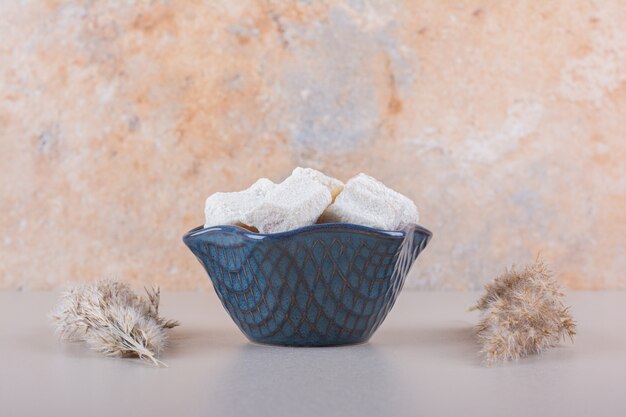 Tigela azul de sobremesas doces com nozes em fundo branco. Foto de alta qualidade