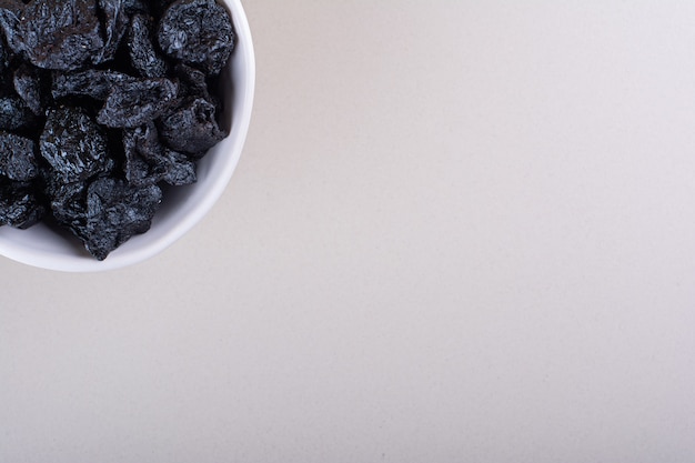 Foto grátis tigela branca de frutas secas de ameixa colocadas sobre fundo branco. foto de alta qualidade