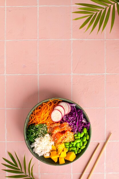 Tigela com arroz de salmão e legumes frescos picar a vista superior Vertical